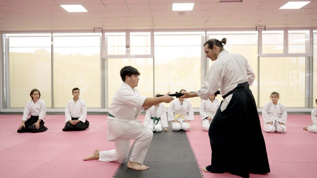 niño practicando aikido con su entrenador